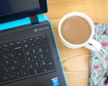 A close-up of a laptop and a cup of tea