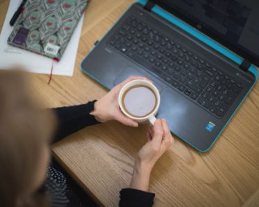 Karen working on her laptop and enjoying a cup of tea