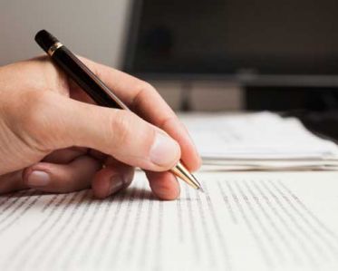 A close-up of someone annotating typed notes with a pen