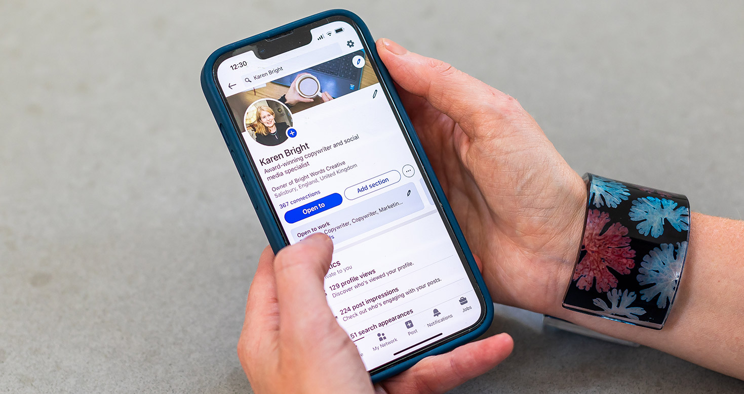 A close up of Karen's LinkedIn profile on her phone