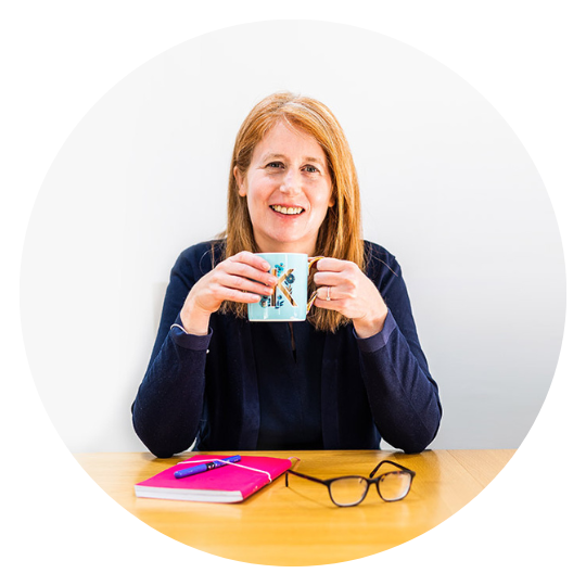 Karen Bright smiling with a cup of tea at a desk