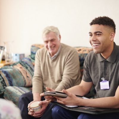 Charity copywriter representer by a charity volunteer with an elderly man.