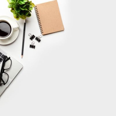 Website copywriter as represented by a photo of a laptop with a cup of coffee, notebook and pencil