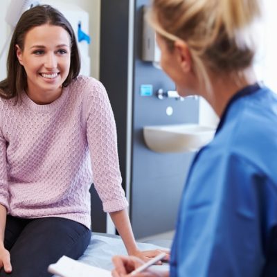 Female Patient And Nurse Have Consultation In Hospital Room Healthcare copywriter represented by a photo of a patient consultation