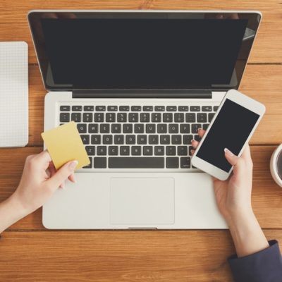 Website copywriter as represented by a person at a laptop with a mobile phone